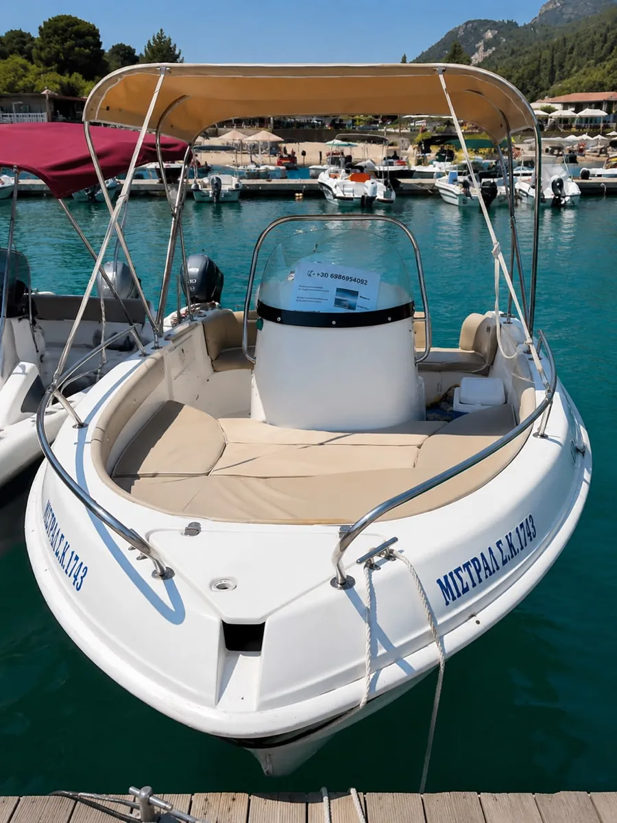The Mistral at its mooring, with the centre console, cushioned bow and tan sun canopy.