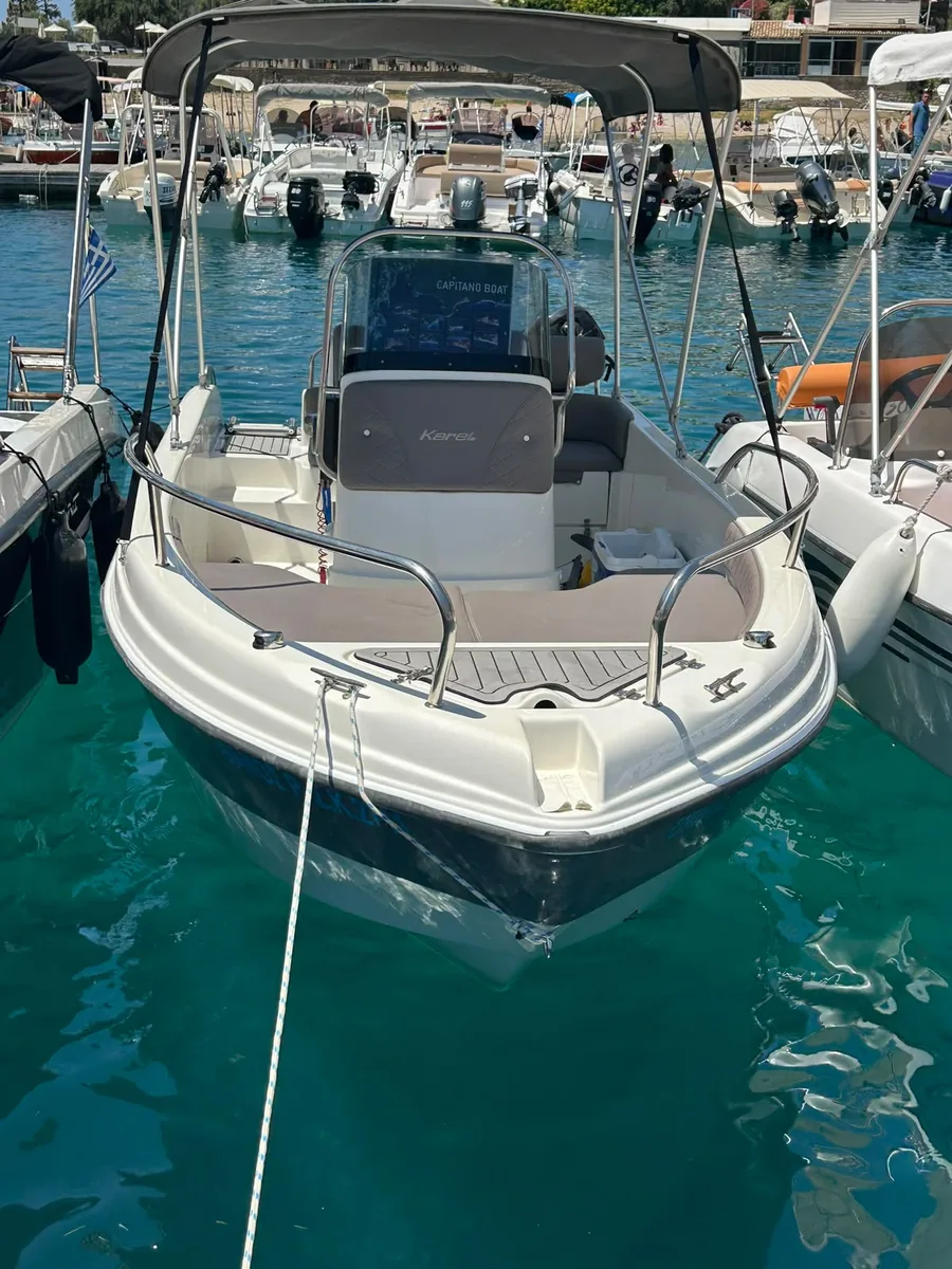 The Thanos at its mooring, with a grey sun canopy over the console and an open foredeck.